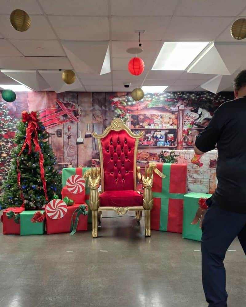 Santa photos in Atlanta: gold chair with a red seat among gift boxes and a lit tree.